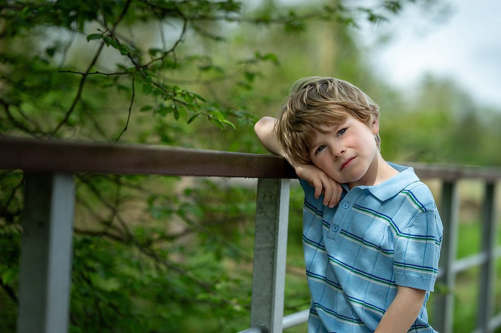 Communicant leunt op een brug.