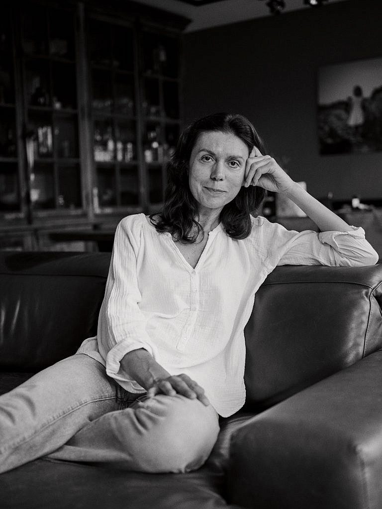 Nele Martens fotograaf in Lievegem zit in de zetel en kijkt recht in de lens.