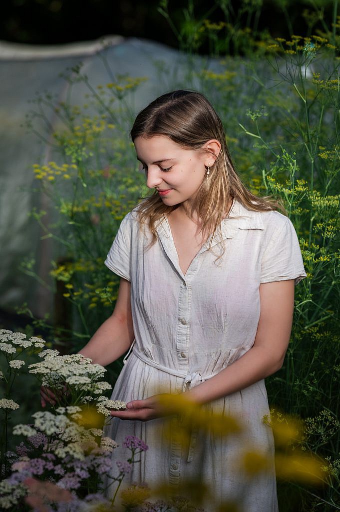 Jong meisje kijkt naar witte bloemen.