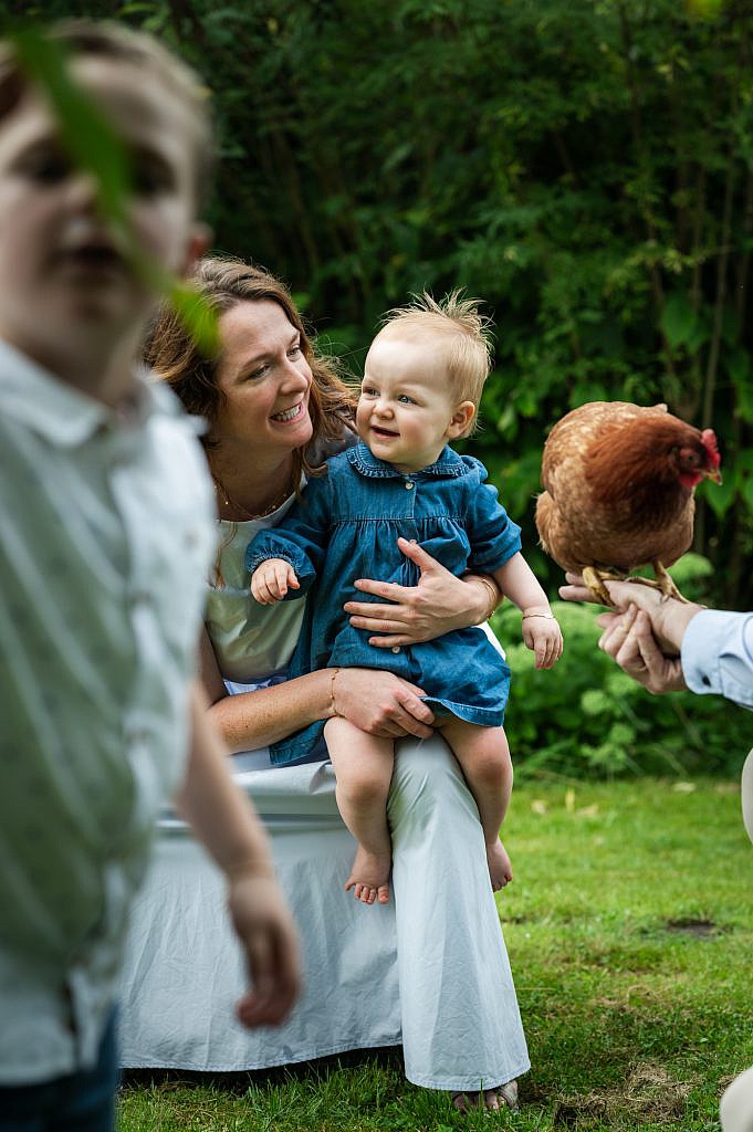 Fotoshoot gezin Lievegem van mama met baby en kip.