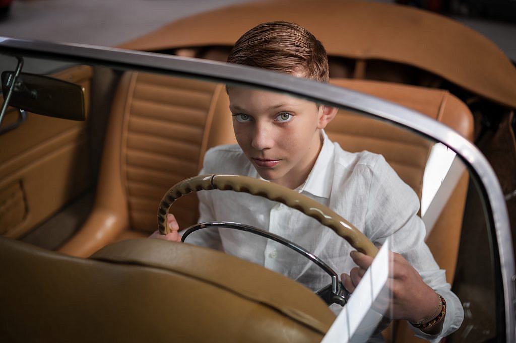 Communicant in auto houdt het stuur vast.