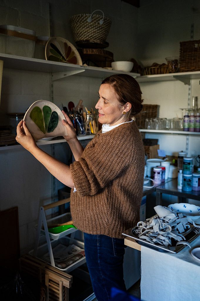 Marianne houdt een staal vast van kleuren in haar atelier.