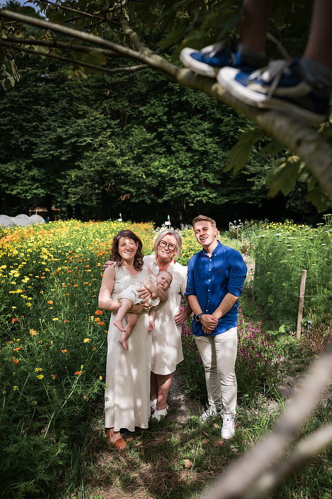 Gezin met oma en kleinkinderen in een bloemenveld.