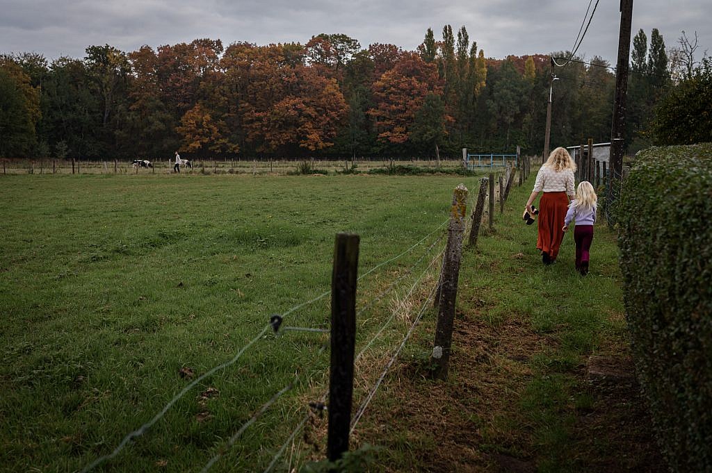 Weids landschap met mama en jong meisje al wandelend aan de hand.