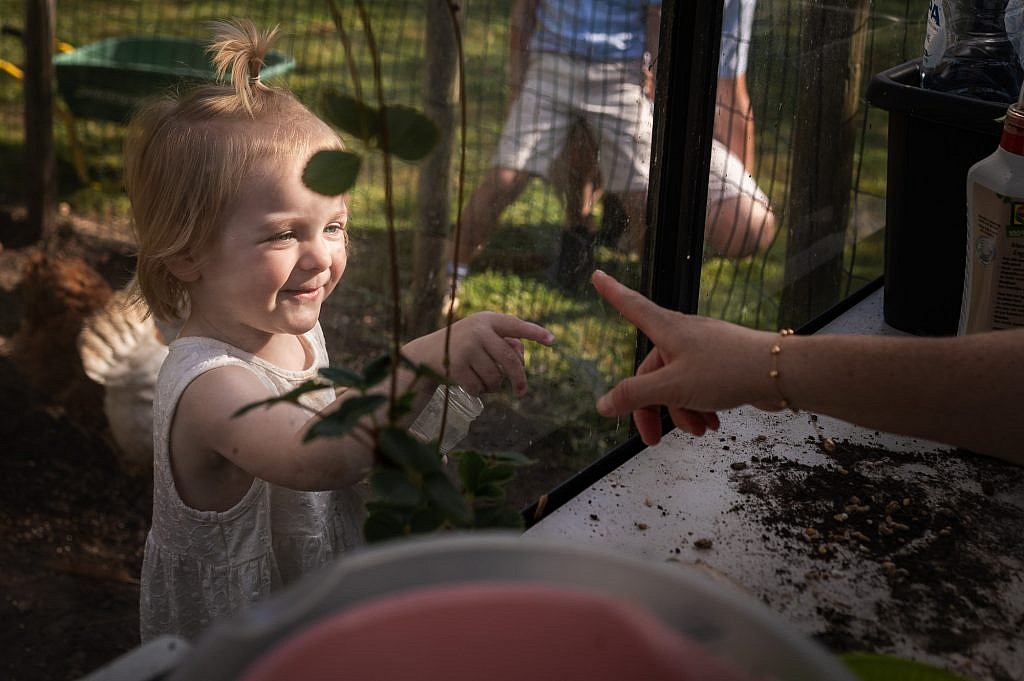 Klein meisje steek haar vingertje uit naar mama door de lens van Nele Martens gezinfotograaf uit Lievegem.
